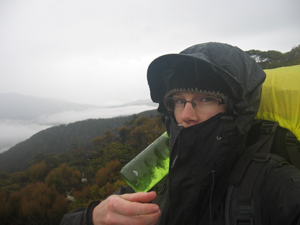 Deborah in a black rain coat with the hood up. Only her eyes and nose are showing.